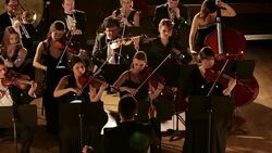 Man conducting orchestra on stage Stock Footage