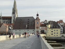 MS People walking over Steinerne Brucke, St. Peter Cathedral on Danube river / Regensburg, Bavaria, Germany Stock Footage