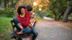 New York couple in love nuzzle closely on park-bench in the heart of Central Park in fall (dolly-shot) Stock Footage