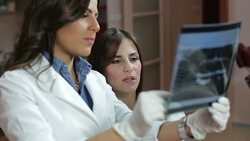 Dentist showing female patient x-rays Stock Footage