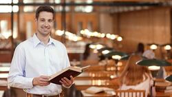 DS Portrait of man with book standing in reading room Stock Footage