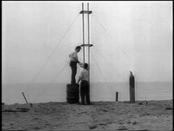 B/W 1933 2 men on beach preparing for launch of world's first liquid-fueled rocket / newsreel Stock Footage