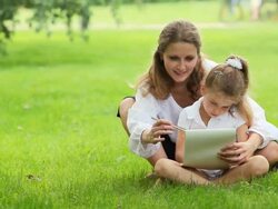 Mother and daughter drawing on grass in park Stock Footage