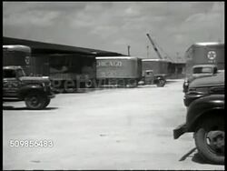 1947: U.S. TRUCKING: HA WS 'Red Star' truck backing into spot, loading platform. WS Trucks parking, moving. INT WS Workers w/ boxes in loading platform building, trucks lined up. MS Workers pushing load into back of truck. Chicago, USA Instructional Video