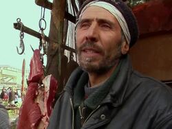 February 2009 CU Butcher talking with someone, beef meat hanging on hook / Kabul, Afghanistan Stock Footage