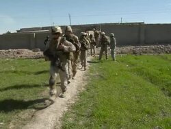 WS Soldier walking in narrow field footpath / Musa Qala, Helmand Province, Afghanistan. Stock Footage