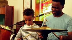 MS Smiling boy playing drums during lesson with father Stock Footage