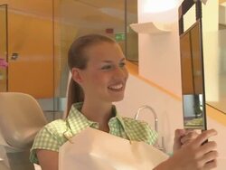 CU PAN Female dental patient smiling at her reflection in mirror and talking with dentist / Berlin, Germany Stock Footage