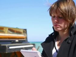 young woman writes on the coast Stock Footage