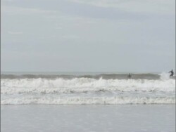 Surfers in sea, UK; 2006; short sequence. Stock Footage