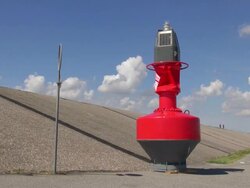 MS Shot of dike at eidersperrwerk and people riding bicycle, Dithmarschen, North Sea / Tonning, Schleswig Holstein, Germany Stock Footage
