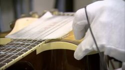 Gloved hands plug in an electric guitar. Stock Footage