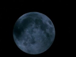MCU Wispy clouds passing across full moon as it rises Stock Footage