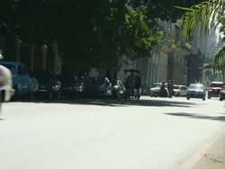 MS Shot of Bustling traffic at Havana street with Vintage american cars and Pedicab / Havana, Cuba  Stock Footage