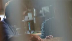 Wood shop workers inspect carved embellishments on custom skateboard Stock Footage
