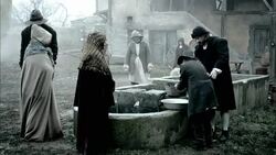 Nostradamus oversees a villager washing his hands in a basin at a well. Stock Footage