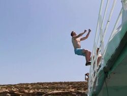 A young man jumping off a boat and doing a backflip in Malta. - Slow Motion - Model Released - HD Stock Footage
