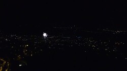 People celebrating the summer solstice in Catalonia at night with fireworks and bonfires in the city streets taken from elevated viewpoint. Stock Footage