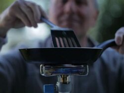 CU mature man cooking on camping stove/Bungay/Suffolk/UK Stock Footage