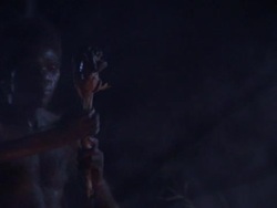 Homo erectus individuals gather around a fire at night in a reenactment. Stock Footage