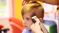 Hairdresser cutting cute childs hair Stock Footage