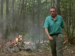 MS PAN Man throwing logs onto blazing fire / Cranbrook, Kent, United Kingdom Stock Footage
