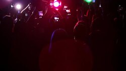 Crowd waving arms holding cell phones at concert Stock Footage
