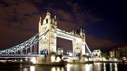 Lights reflect on the Thames River as traffic travels across Tower Bridge in London, England. Stock Footage