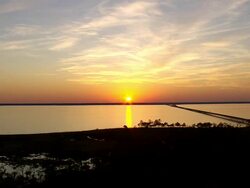 WS AERIAL View of Sunset over Colington Island shore with bridge on lake / North Carolina, United States Stock Footage