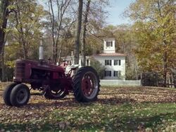 New England farmhouse with rusted tractor fall Stock Footage