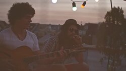 Playing guitar with friend on rooftop party Stock Footage