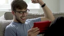 Watching sport on digital tablet, punching air. Stock Footage