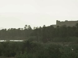 Moroccan shrubs and vegetation fill the foreground, with a backdrop of a fort like building and hazy mountain ranges. Stock Footage