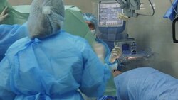 Nurse coveres patient's face to start an eye operation Stock Footage