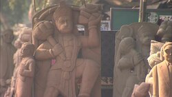Stone gods and goddesses decorate a rural road in India. Stock Footage