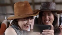 Two young women look at smartphone and laugh Stock Footage