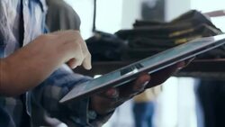 Modern clothing store employee types on tablet and counts products on shelves Stock Footage