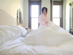 Woman making bed with baby son Stock Footage