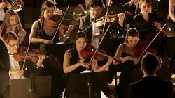 Man conducting orchestra on stage Stock Footage