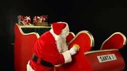 Father Christmas, Santa polishing his sleigh ready for use Stock Footage
