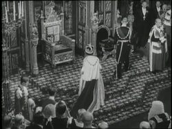British Queen Elizabeth II and Prince Philip sit on their thrones as members of Parliament stand before them. News Clip