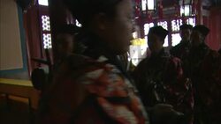 A line of men in traditional clothing bow with musical instruments inside a room in Beijing, China. Stock Footage