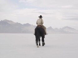 Cowboy riding horse on salt flats. Stock Footage