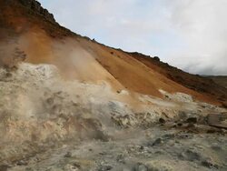 WS Boiling water on earth's crust and steam rising in Krysuvik Geothermal area, orange mountains surround area / Reykjanes peninsula, Iceland    Stock Footage
