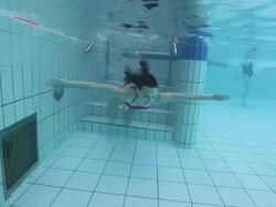 Young woman in pink bikini stepping into swimming pool Stock Footage