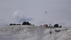 Parachute flying over  travertines in Pamukkale Stock Footage