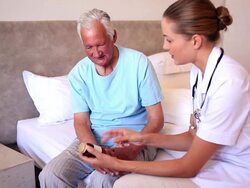 Home nurse explaining medicine to elderly patient Stock Footage