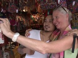 CU ZI ZO Woman photographing self with gift shop owner, Bangkok, Thailand Stock Footage