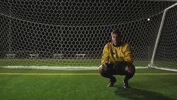 A goalie crouches in front of the net and buries his head in his hands. Stock Footage