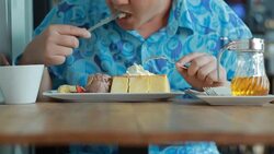 Happy young man eating delicious cake in cafe Stock Footage